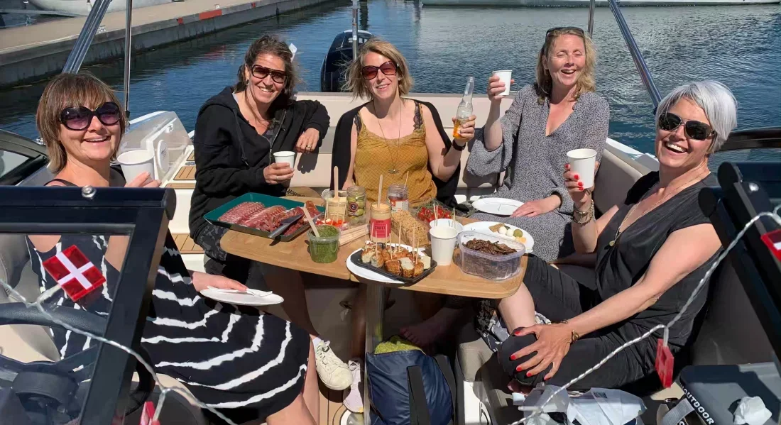Billede af Ann's veninder med drinks i hånden på Ann's nye båd.